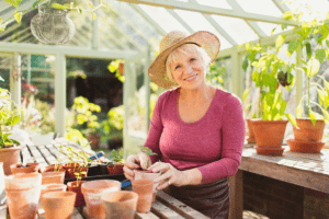 woman smiling with plant in greenhouse