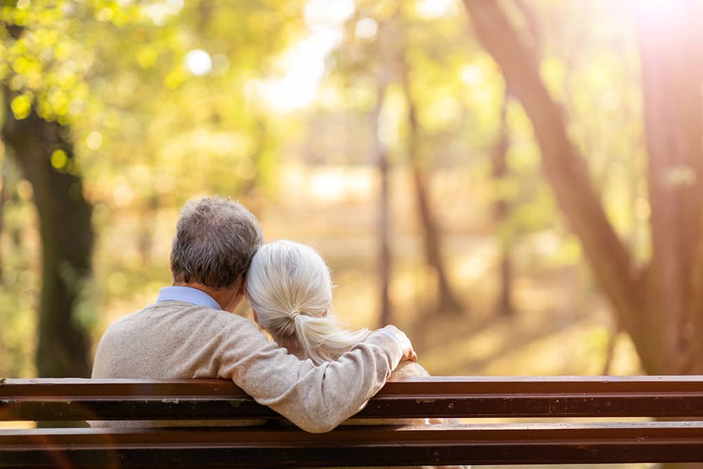 couple sitting on bench in autumn forest